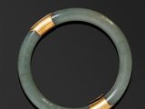 un gros plan d'un bracelet vert posé sur une surface noire