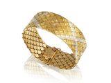 gros plan d'un bracelet en or sur fond blanc