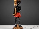 une statue noire et dorée représentant une femme tenant une torche