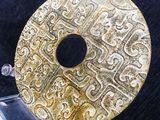 a gold coin on a clear stand on a black surface