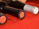 three bottles of wine sitting on a red cloth