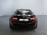 the rear end of a black sports car in a white room