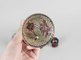a person holding a small bowl with flowers in it
