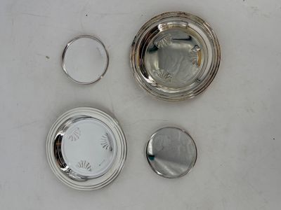une assiette en argent et une tasse en argent posées sur une table blanche