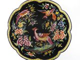 a black plate with colorful birds and flowers on it