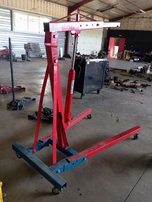 une photo d'un garage avec un grand pont élévateur rouge