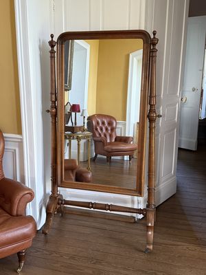une photo d'un salon avec un fauteuil et un grand miroir