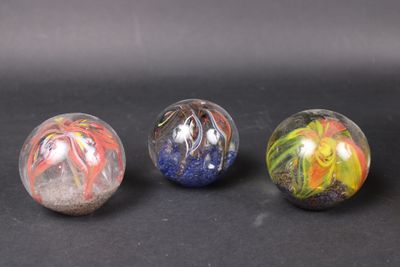 three marble balls with different designs on them on a black surface