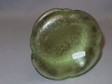 a green vase sitting on a table with a tag on it