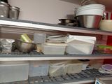 many pots and pans on the shelves in the kitchen