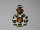 une médaille dorée et verte surmontée d'une couronne