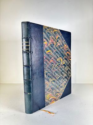 an old blue book sitting on top of a white table