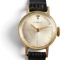 a gold wrist watch with a black leather strap