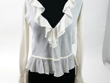 a white blouse with ruffles on a mannequin