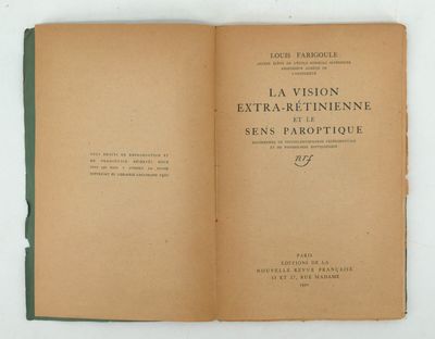 un livre ouvert posé sur une table à côté d'un mur blanc