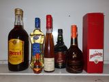 Des bouteilles d'alcool sont alignées sur une étagère à côté d'une boîte rouge