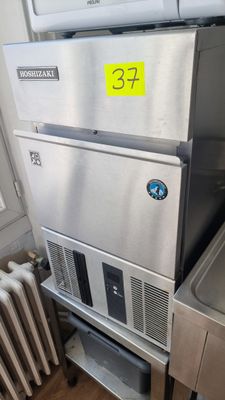 un réfrigérateur en acier inoxydable situé à côté d'un évier et d'un radiateur