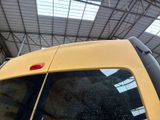 a yellow van parked inside of a building with a skylight