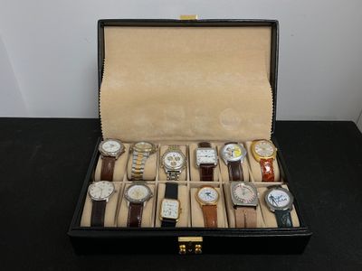 de nombreuses montres dans un coffret noir posées sur une table