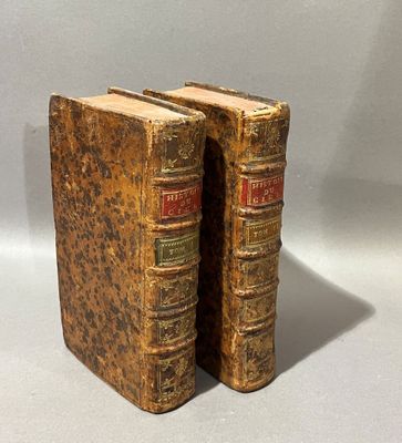 deux vieux livres posés l'un sur l'autre sur une table