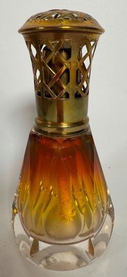 a small glass vase with a gold top on a table