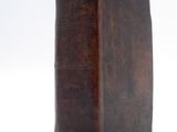 an old brown book sitting on top of a table next to a white background