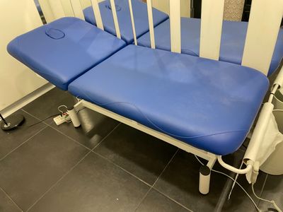 un lit d'hôpital bleu et blanc dans une chambre