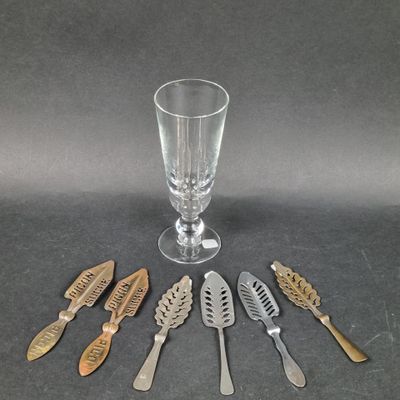 five spoons and a glass on the table