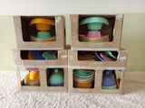 several boxes of colorful dishes and cups are stacked on top of each other