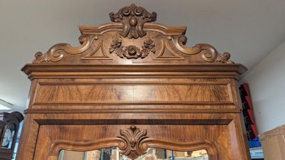 a large wooden grandfather clock with a mirror in the middle of it