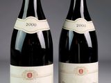 two bottles of red wine sitting next to each other on a table