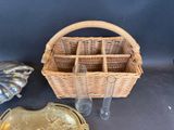 a wicker basket with glasses and a gold plate on the table