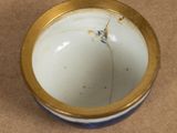 a white bowl with a gold rim sitting on a table