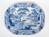 une assiette bleue et blanche avec un paysage dessus