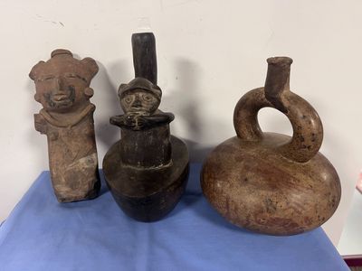 trois vases sont posés sur une nappe bleue, sur une table