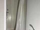 a white shower curtain hanging in the corner of a bathroom