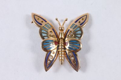 broche en forme de papillon avec des ailes en émail bleu et jaune sur fond blanc