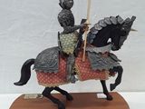 figurine of a knight on a horse with a red flag