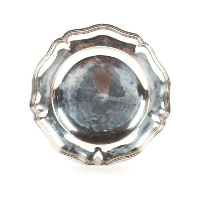 une assiette en argent sur fond blanc avec un fond noir