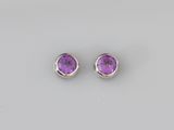 une paire de boucles d'oreilles en améthorate sur fond blanc