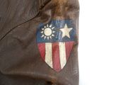 une veste en cuir marron ornée d'un écusson et d'étoiles