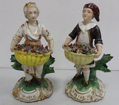 paire de figurines représentant un garçon et une fille avec des paniers de raisins