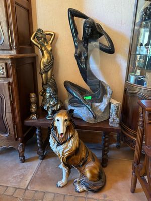 une statue représentant un chien assis à côté d'une statue représentant une femme