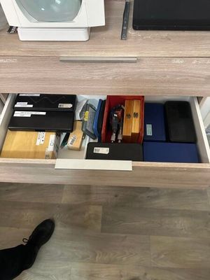 un bureau muni d'un tiroir contenant divers objets