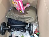 a cardboard box filled with toys and a baby ' s stroller