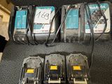 quatre batteries Makita et un chargeur posés sur une chaise