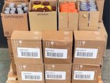 several boxes of sodas are stacked on a pallet in front of a black wall