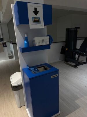 une photo d'une salle de sport avec une armoire bleue et des toilettes blanches