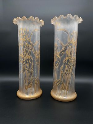 deux vases ornés de motifs dorés, posés sur une surface noire