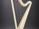une harpe blanche posée sur un support en bois